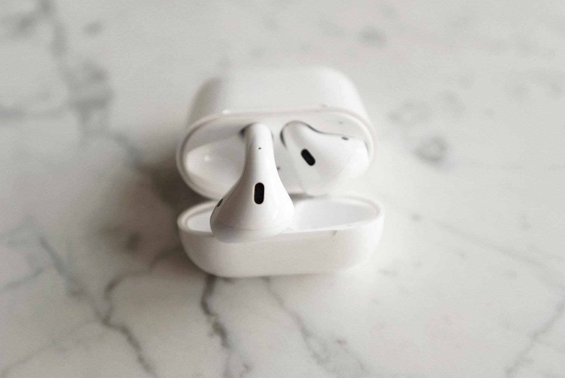 AirPods 4 posés sur une surface claire avec leur boîtier de charge ouvert